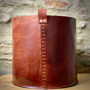 Load image into Gallery viewer, Leather Storage Bin for kindling, throws, toys or a large plant pot.  Oak bark veg-tanned leather in Dark London Tan.  Hand-stitched base using traditional saddler stitch for extra strength and loop attached using ladder stitch and copper rivets