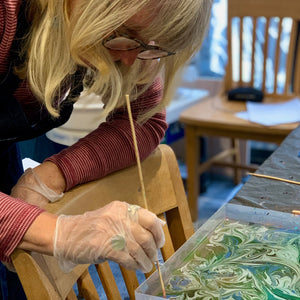 Load image into Gallery viewer, ROCWORX workshop participant concentrating on making a Green Teal Swirl pattern using a stylus