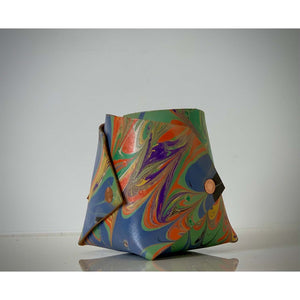 Load image into Gallery viewer, ROCWORX Marbled veg-tanned leather Origami inspired vessel in abstract pattern of purple, orange, green and gold.  Finished with copper rivets