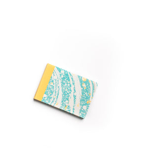 Load image into Gallery viewer, ROCWORX A5 Marbled hand-stitched sketchbook, with protective yellow cloth spine. Suminagashi circles pattern in Teal and White with Gold
