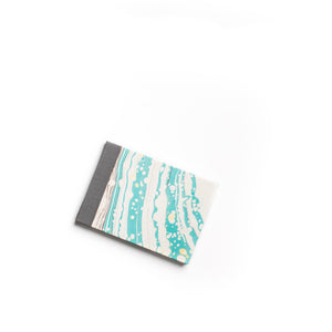 Load image into Gallery viewer, ROCWORX A5 Marbled hand-stitched sketchbook, with protective grey cloth spine. Suminagashi circles pattern in Teal and Black with Gold
