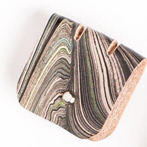 Load image into Gallery viewer, Marbled veg-tanned leather cable tidy, abstract monochrome pattern with silver button closure 

