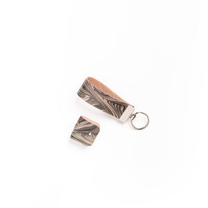 Load image into Gallery viewer, Marbled leather key fob, in abstract monochrome pattern set on a silver key ring.  Cable tidy in abstract marbled leather with silver button closure
