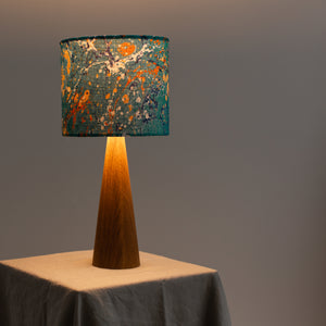 Load image into Gallery viewer, Lamp lit to show linen lampshade on wooden base.  Lampshade Stone marbling pattern in dark teal and dark peach
