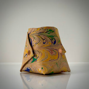 Load image into Gallery viewer, Marbled veg-tanned leather Origami inspired vessel.  Abstract pattern in Yellow gold, cherry red, dark green and blue. Finished with copper rivets.
