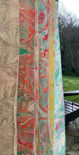 Marbled silk scarves hanging to dry in the garden.